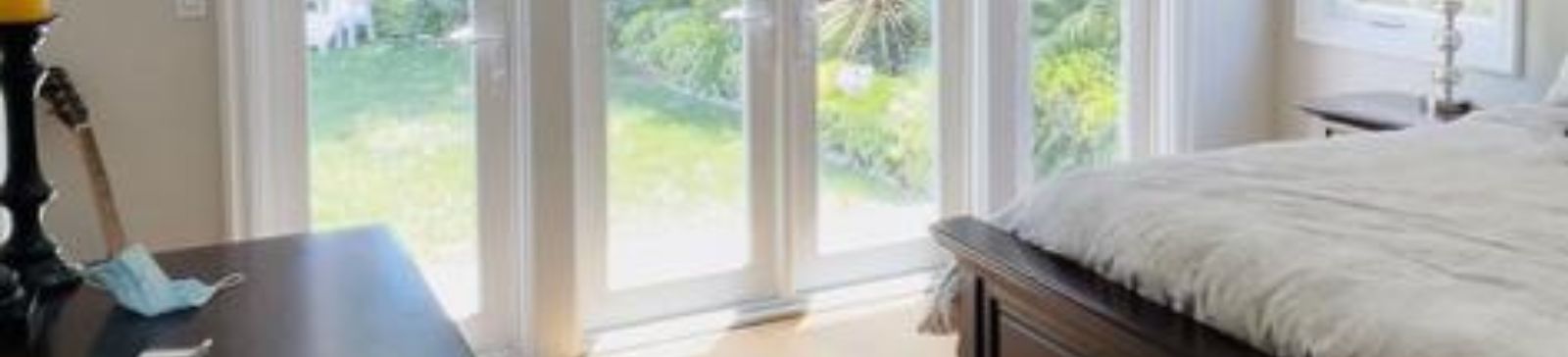 Bright West Hollywood bedroom showcasing Roman shades partially raised to reveal natural garden views.